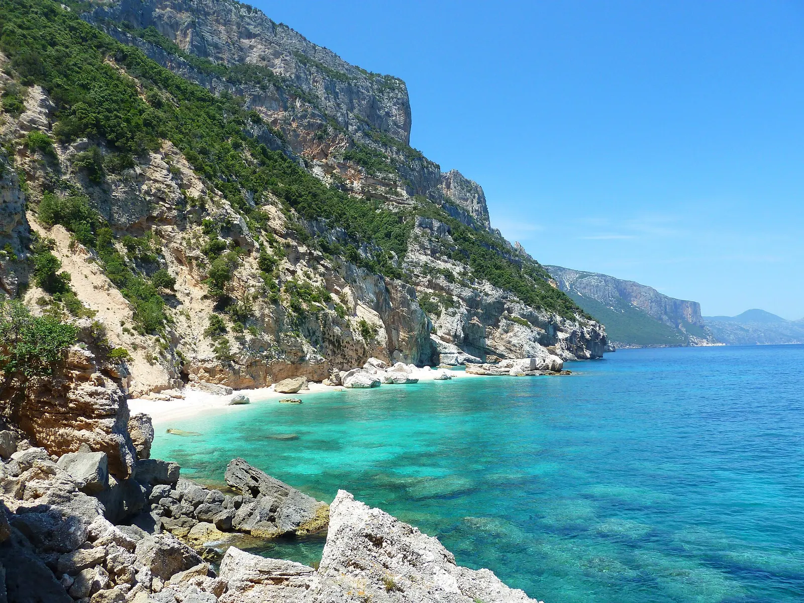 Cala Mariolu vista dall’alto, ciottoli chiari e acqua turchese sotto le falesie