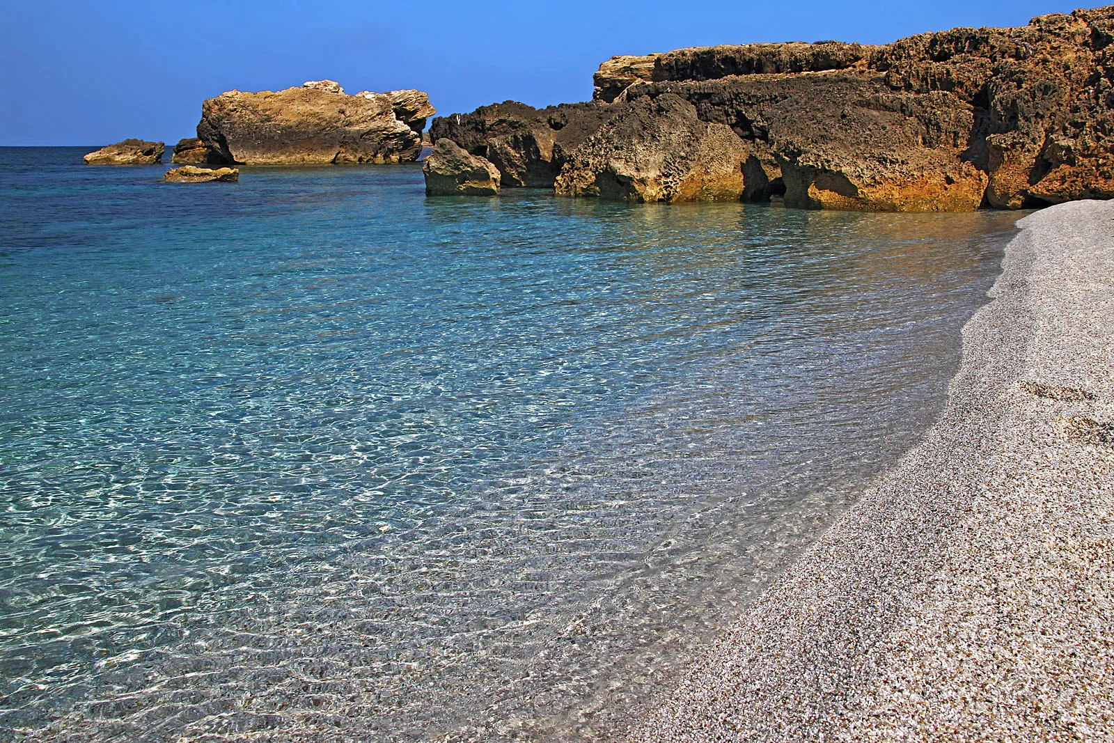 Is Arutas nel Sinis: granelli di quarzo, acqua chiara e scogli calcarei